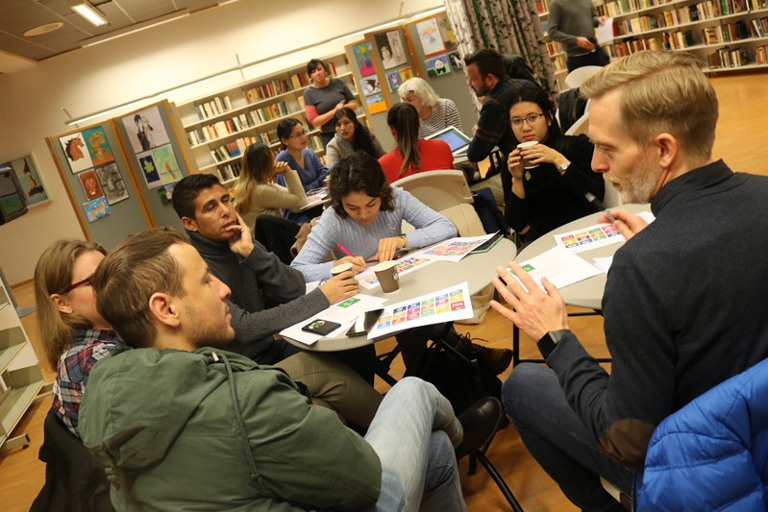 En gruppe mennesker som sitter rundt et bord i et bibliotek.