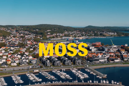 Et flyfoto av en by med båter i vannet.