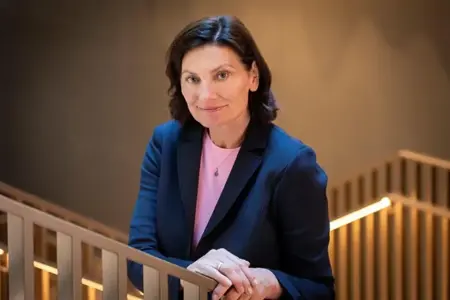 En kvinne står på en balkong ved siden av et rekkverk.