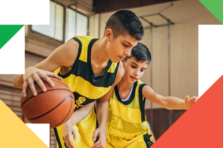 Et par unge menn som står ved siden av en basketball.