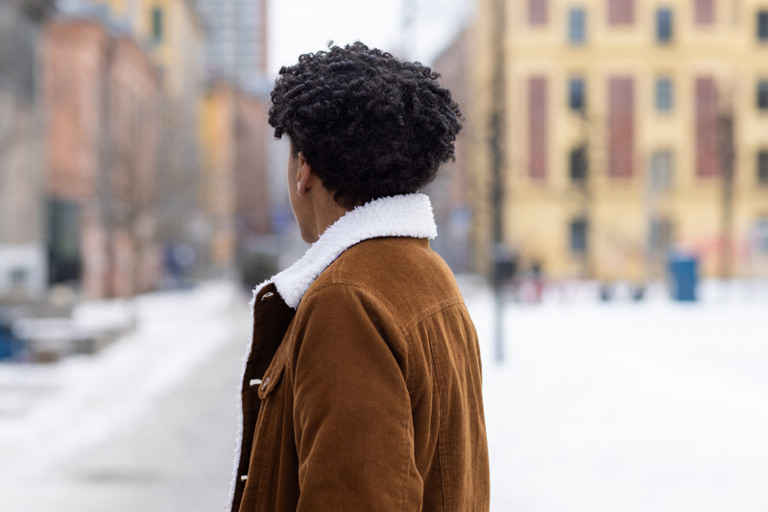 En mann som står midt i en snødekt gate.